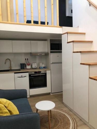 un salon avec un canapé bleu et une cuisine dans l'établissement Duplex neuf, 15mn de Paris, parking, climatisation, à Bourg-la-Reine