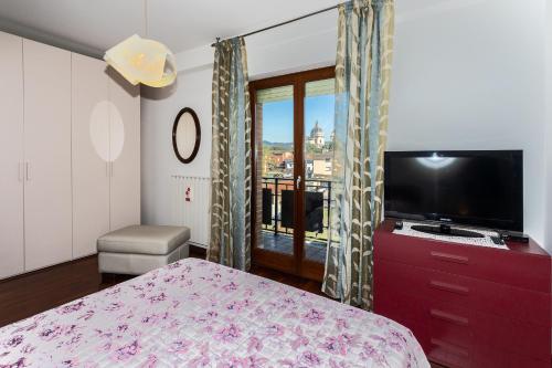 um quarto com uma cama, uma televisão e uma janela em Gli Angeli em Assis