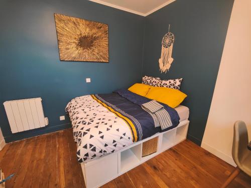 une chambre avec un lit avec un mur bleu dans l'établissement Le Chic, à Ivry-sur-Seine