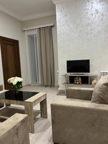 a living room with a couch and a tv at Appartement in Yerevan in Yerevan