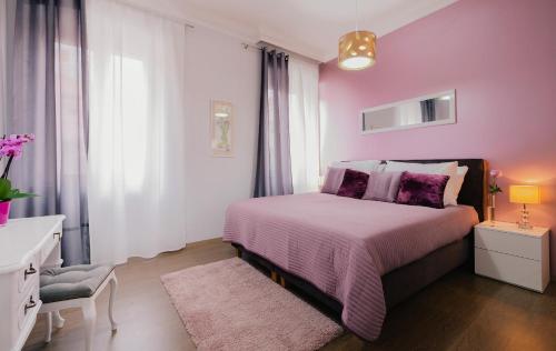 a pink bedroom with a bed and a chair at Apartment for special getaway Nea in Pula