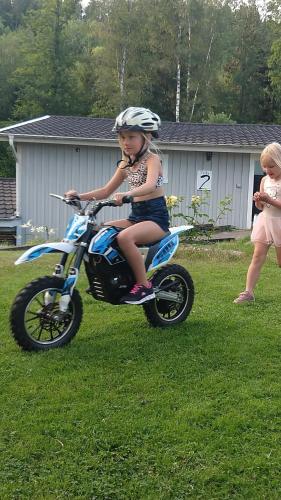 a young girl riding a dirt bike in the grass at Évika boutique hotel in Eskilsby