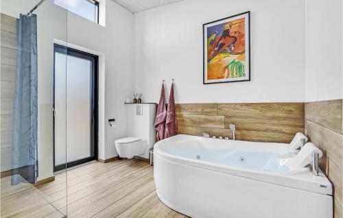 a white bath tub in a bathroom with a window at 5 Bedroom Cozy Home In Hadsund in Hadsund