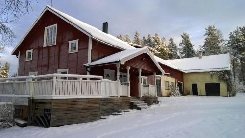 a red house with snow on the porch at Näsets Marcusgård in Furudal