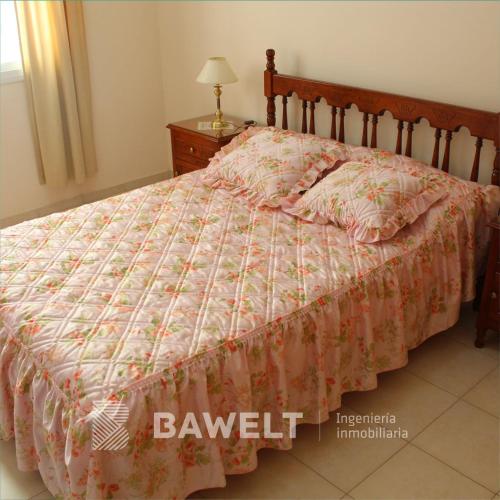 1 dormitorio con cama con edredón en Marianella Apart Familiar en Río Cuarto