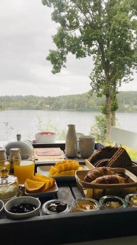 a table with food and a view of a lake at Évika boutique hotel in Eskilsby
