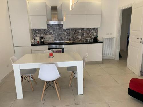 cocina blanca con mesa blanca y sillas en Agasweethome Rome Gemelli en Roma