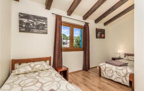 a bedroom with two beds and a window at Nice Home In Palit With Wifi in Mundanije