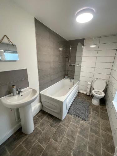 La salle de bains est pourvue d'une baignoire, de toilettes et d'un lavabo. dans l'établissement Modern Spacious 2 Bedroom Apt, à Rowley Regis