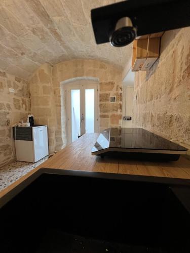 cocina con encimera y pared de piedra en La PortaVecchia - #Home, en Monopoli