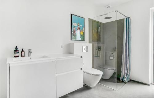 uma casa de banho branca com um lavatório e um WC em 5 Bedroom Beautiful Home In Sjllands Odde em Yderby