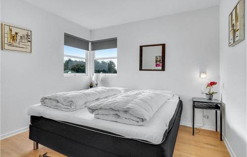 a bedroom with a bed with white sheets and a window at 3 Bedroom Lovely Home In Hemmet in Falen