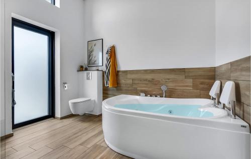 uma casa de banho branca com uma banheira e um WC em Pet Friendly Home In Hadsund With Sauna em Hadsund