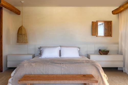 a bedroom with a bed with two pillows and a table at Casa Capim Cidró in Alto Paraíso de Goiás