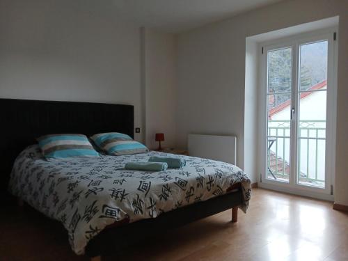 1 dormitorio con cama y ventana grande en T2 50m2 résidence les Acacias Vue Dégagée Montagne en Ax-les-Thermes