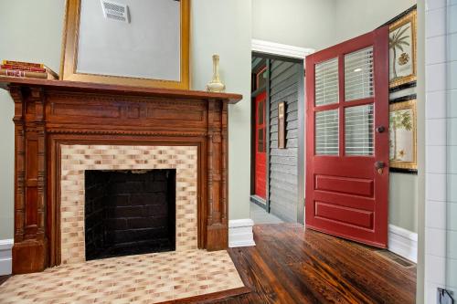 a living room with a fireplace and a red door at Summit Street Inns in Winston-Salem