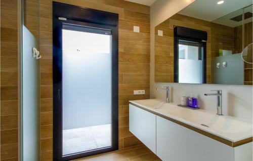 La salle de bains est pourvue d'un lavabo et d'un miroir. dans l'établissement Stunning Home In Dehesa De Campoamor With Outdoor Swimming Pool, Wifi And Swimming Pool, à Campoamor