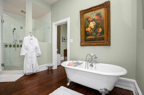 a white bath tub in a bathroom with a painting at Summit Street Inns in Winston-Salem