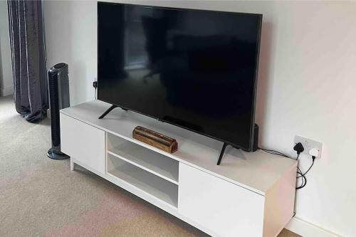 a flat screen tv sitting on a white entertainment center at Lovely one bedroom apartment with balcony in Forest Hill