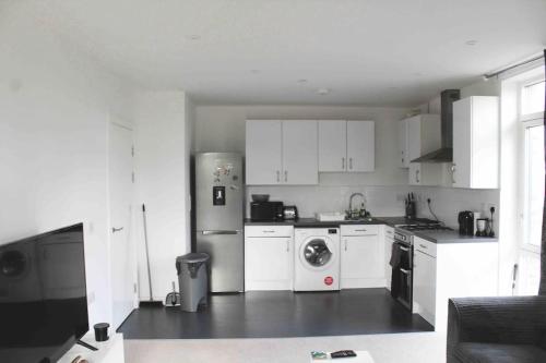 a kitchen with a refrigerator and a washing machine at Lovely one bedroom apartment with balcony in Forest Hill