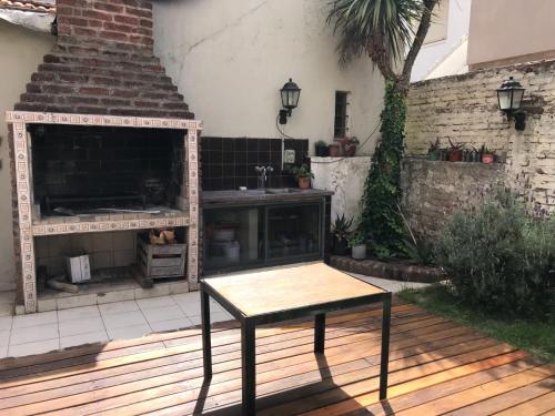 una mesa en una terraza de madera con chimenea en Casa La Perla en Mar del Plata