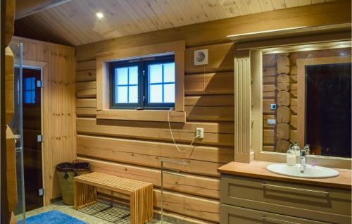 a bathroom with wooden walls and a sink and a window at Beautiful Home In yer With Sauna, 5 Bedrooms And Wifi in Øyer