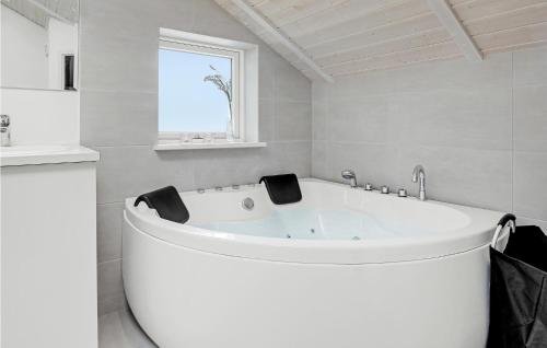 a white bath tub in a bathroom with a window at Stunning Home In Nex With Sauna in Neksø