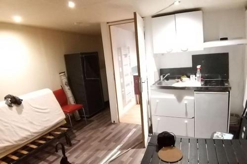 Habitación con cama y cocina con fregadero en Chambre équipée (proche Paris), en Argenteuil