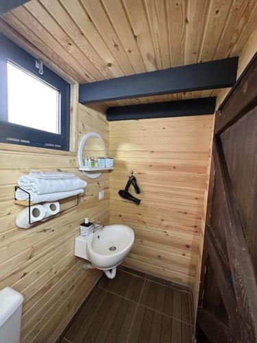 a bathroom with a wooden wall with a sink at 5- Modern tasarım ahşap ev in Çatalca