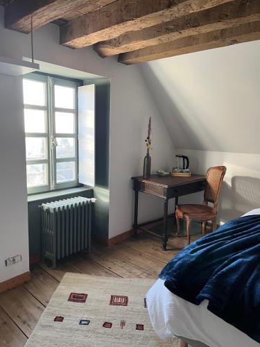 a bedroom with a desk and a bed and a table at Mercier de Montigny - Les Chambres du Beffroi - SPA et Massage in Fougères