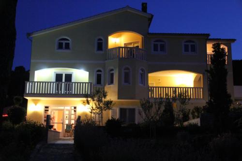 Une grande maison blanche éclairée la nuit dans l'établissement Apartments Villa Lora, à Kraj