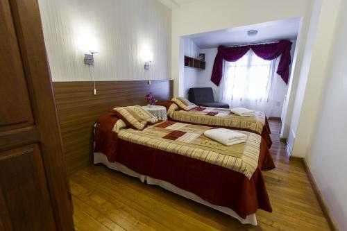 a hotel room with two beds and a window at Bed and Breakfast Aijpel in Ushuaia