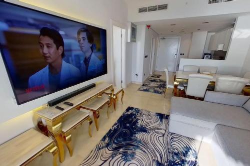 a living room with a large flat screen tv on a wall at شقة في برج داماك بإطلالة بحرية ساحرة in Jeddah