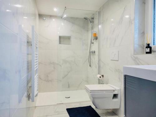 a bathroom with a shower and a toilet and a sink at 100m2 2 chambres 8 personnes - Grand parking et terrasse privée - Proche CDG-Parc expositions-Paris-Astérix-Disney in Villepinte