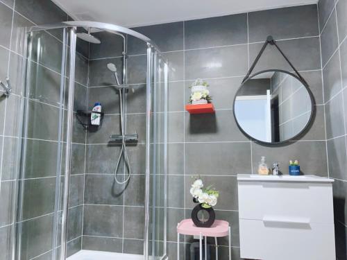 La salle de bains est pourvue d'une douche avec un miroir et un tabouret. dans l'établissement Apt 67m2 hyper centre: 2 chambres, cuisine TV wifi, à Fontenay-le-Comte