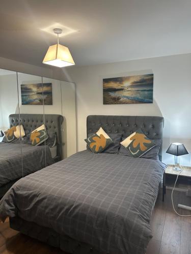 a bedroom with a bed with a gray comforter at Beautiful- Dream Ground Floor one bedroom apartment in London