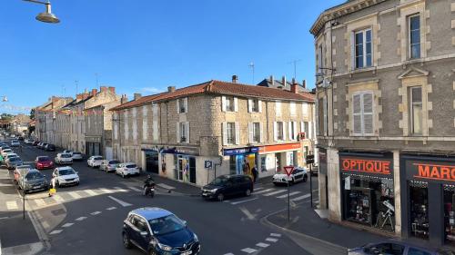una strada cittadina con auto parcheggiate sulla strada di La Mimi, Grand T2 hyper centre ville a Fontenay-le-Comte