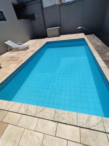 a swimming pool with blue tiles on the floor at Casa Por do Sol in Itanhaém
