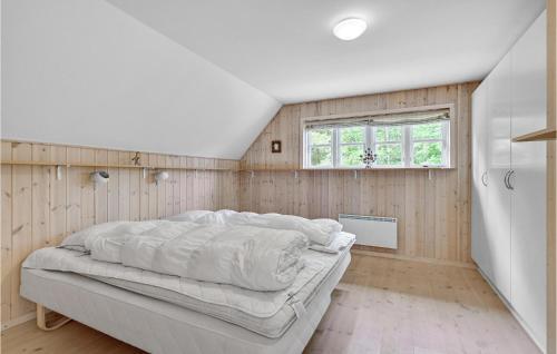 ØhuseにあるLovely Home In Ulfborg With Saunaの木製の壁のベッドルーム1室(ベッド1台付)