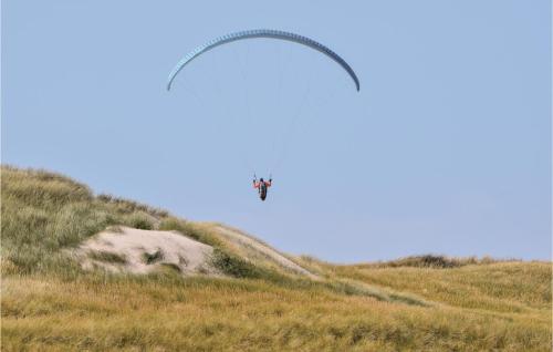 two planes are flying over a grassy hill at Lovely Home In Ulfborg With Sauna in Øhuse