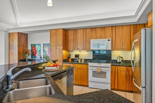 uma cozinha com armários de madeira e electrodomésticos de aço inoxidável em Walk to Beach&Sunset - Luxury Villa on the Princeville Golf Course em Princeville