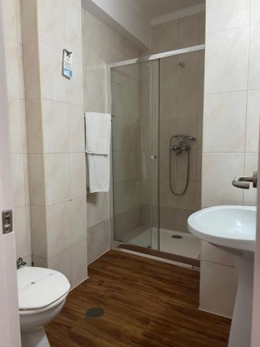 a bathroom with a shower and a toilet and a sink at Hotel Ilha in Angra do Heroísmo