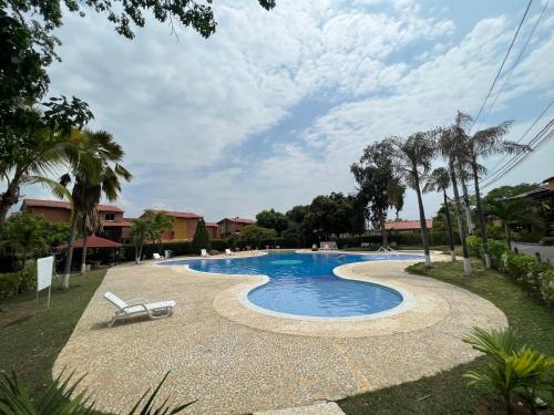 una piscina con una silla y palmeras en Casa de verano, en Santa Fe de Antioquia