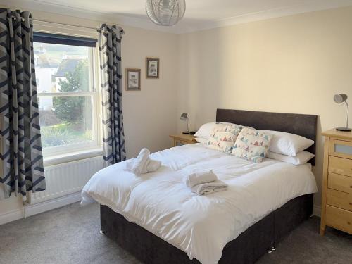 a bedroom with a large bed with a window at 5 Shoreside in Shaldon