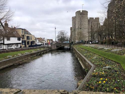 a river in a city with a castle in the background at Charming 2 bedroom flat in Canterbury