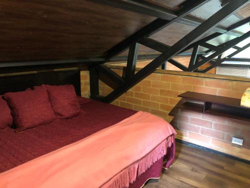 a bedroom with a bed in a brick wall at Cabaña Campestre La Rayuela-Fuquene in Fúquene