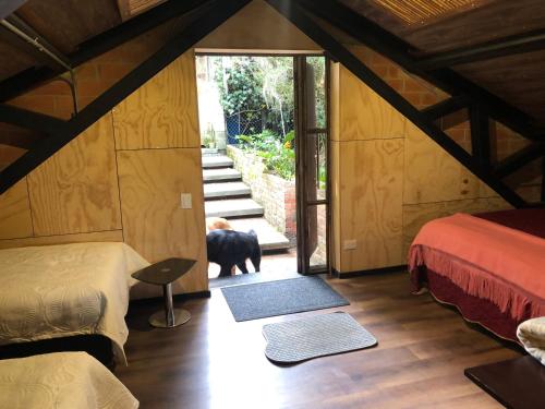 una habitación con 2 camas y un perro mirando por la puerta en Cabaña Campestre La Rayuela-Fuquene, en Fúquene
