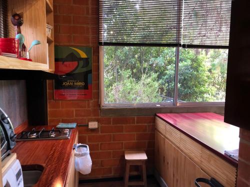 a kitchen with a brick wall and a window at Cabaña Campestre La Rayuela-Fuquene in Fúquene