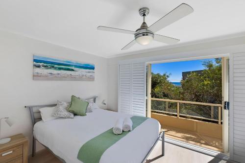a bedroom with a bed and a large window at Pacific Breeze 11 in Blue Bay 