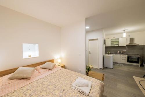 a bedroom with a large bed and a kitchen at Bozena's studio apartment in Split